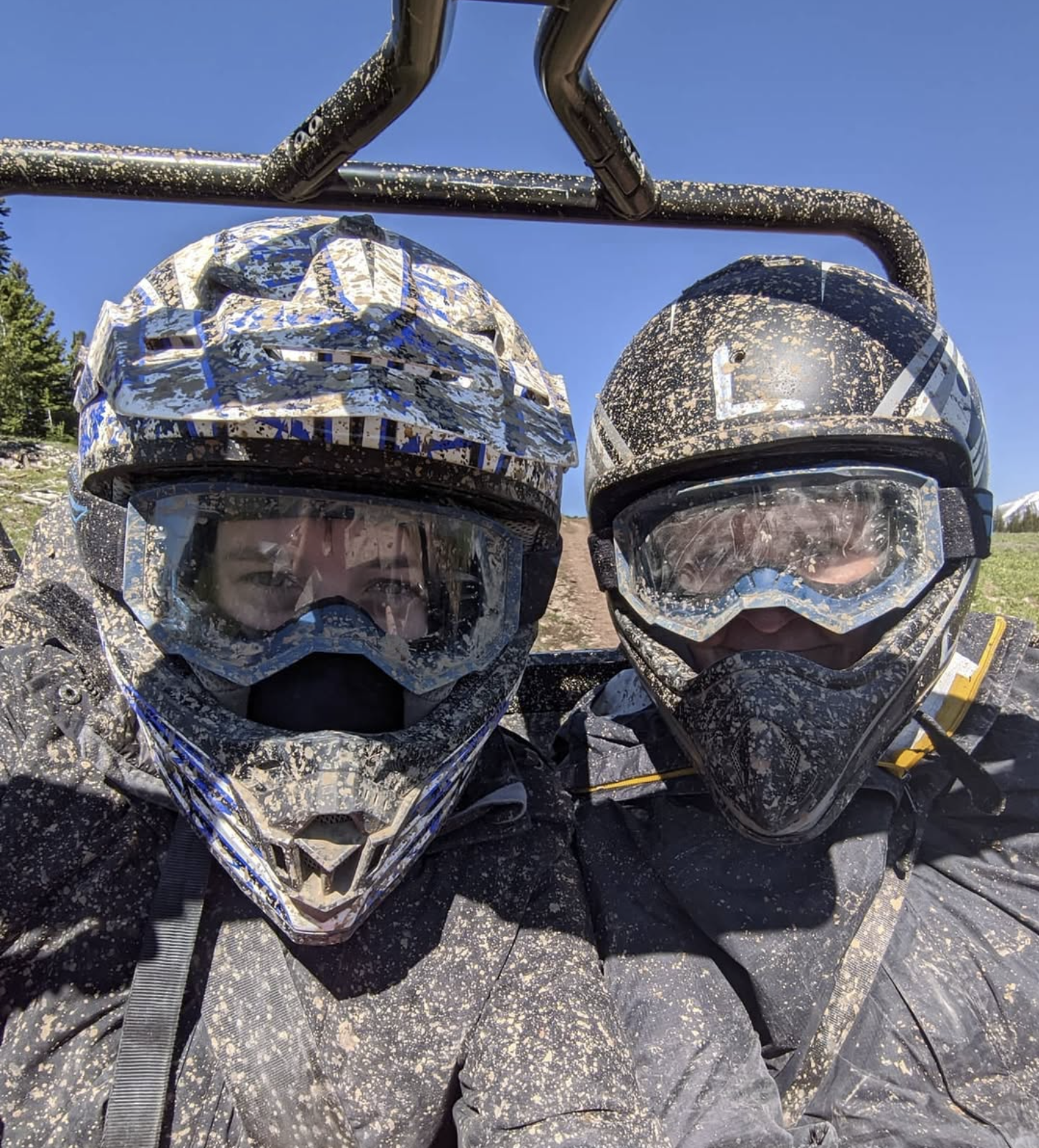 Self-portrait of a skiier who is posing in front of a vista of mountains.