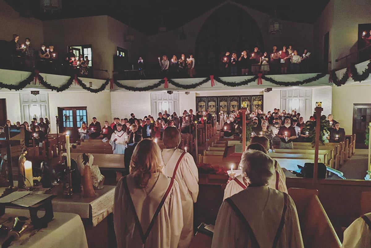 A view of a church congregation from the point of view of a choir member. A full sanctuary; many wear robes.