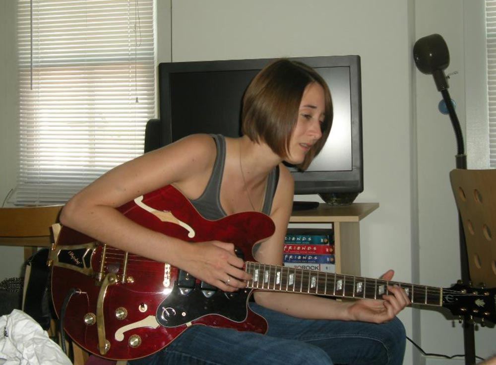 A woman playing a guitar.